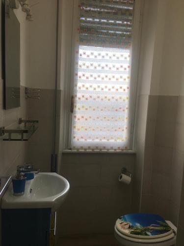 a bathroom with a sink and a toilet and a window at NEAR THE BEACH in Rapallo