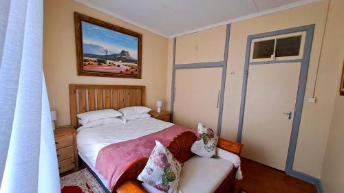 um pequeno quarto com uma cama e um sofá em Pine Forest Cottage em Sabie