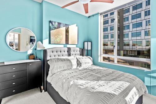 a blue bedroom with a bed and a mirror at Corazon Vista by Iris Properties! in Victoria