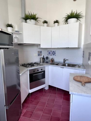 a kitchen with white cabinets and stainless steel appliances at Il Conventino delle Cinque Terre - Sea View - AC&WiFi - Vernazzarentals in Vernazza