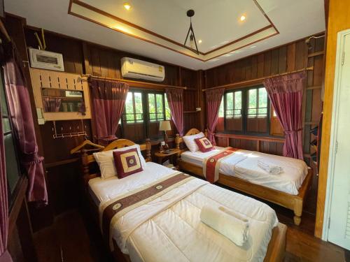 a room with two beds in a room at PunNa Homestay @ Bangsai in Ban Bang Sai