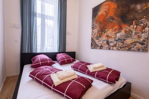 una camera da letto con un letto con cuscini viola e un dipinto di Banksy by prater park close to city centre a Vienna