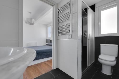 a bathroom with a sink and a toilet and a bed at Levante Sunset Front line apartment Almadraba in Benidorm