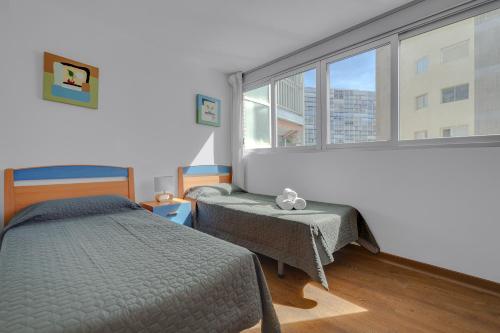 a bedroom with two beds and a large window at Levante Sunset Front line apartment Almadraba in Benidorm