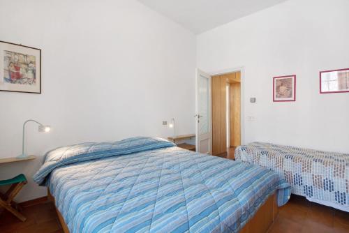 a bedroom with a bed with a blue comforter at Via Colombo 12 Bilo in Bonassola