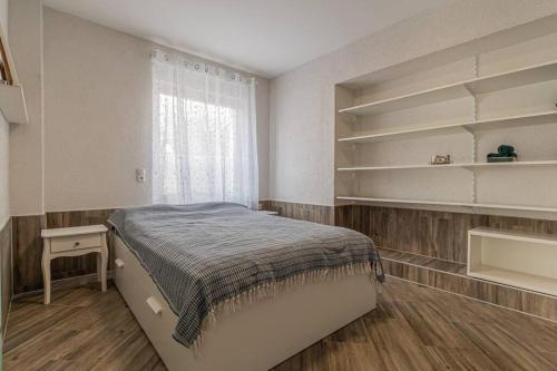 ein Schlafzimmer mit einem Bett, einem Fenster und Regalen in der Unterkunft Gemütliches Apartment in Neuwied in Neuwied