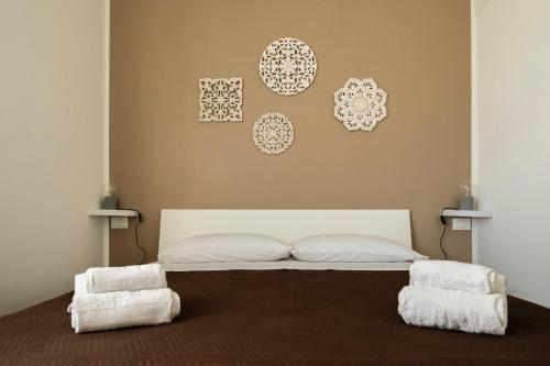 - une chambre dotée d'un lit avec des oreillers blancs et des assiettes murales dans l'établissement Casa di Domy, à Monopoli