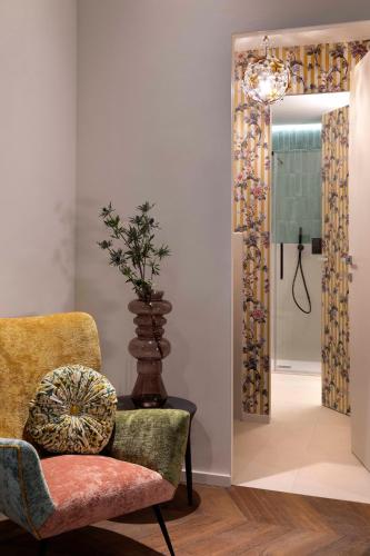 a living room with a chair and a mirror at Agora' - Boutique Stays in Turin