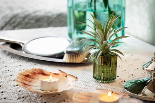 a table with candles and a plate with a plant at Strandflickornas Havshotell Lysekil in Lysekil