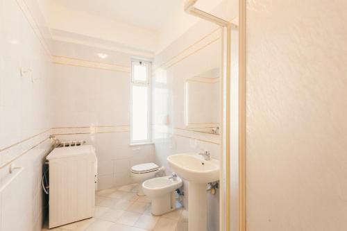 uma casa de banho branca com um WC e um lavatório em CA' DA VINCI em Noli