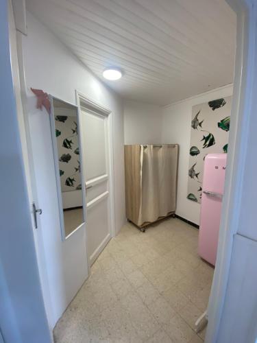 a small room with a door and a refrigerator at Studio de la mer in La Croix-Valmer