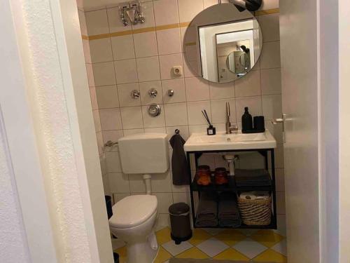 ein Badezimmer mit einem weißen WC und einem Waschbecken in der Unterkunft BOSTEL 89 - Moderne Stadtwohnung in Moers-Zentrum in Moers