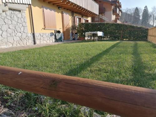una cerca frente a una casa con un patio en Residence La Pineta, en Serina