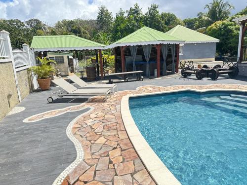 een zwembad met een patio en een huis bij Villas O Soleil in Sainte-Rose