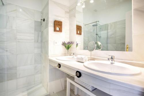 Baño blanco con 2 lavabos y espejo en Genteel Home Salvador Terrace, en Sevilla