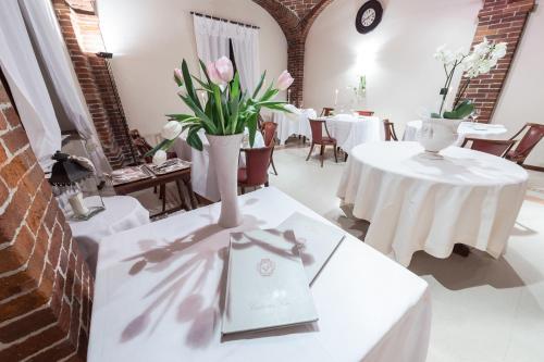 a room with two tables and a vase with flowers on it at Ristorante Albergo Ca' Vittoria in Tigliole
