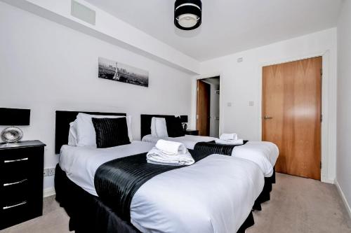 two beds in a room with white and black at Orange Apartments - Kepplestone in Aberdeen