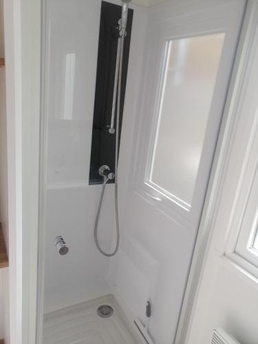 a shower in a bathroom next to a window at MHVACANCES LOUENT PLUSIEURS MOBILHOMES DANS CAMPING 4 ETOILES PROCHE CHATEAUX et ZOO BEAUVAL in Onzain