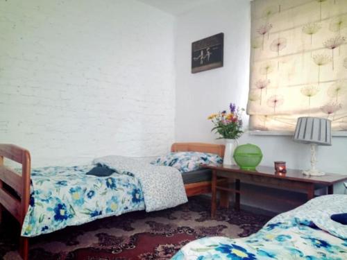 1 dormitorio con 2 camas y mesa con lámpara en Dom Podróżnika -aktywne wakacje, en Jabłonowo