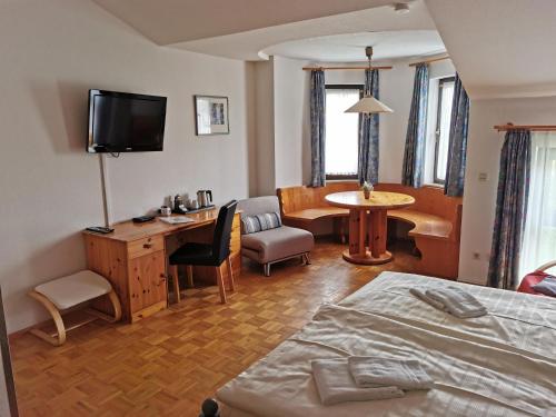 um quarto com uma cama, uma secretária e uma mesa em Schwarzwald Sportzentrum Neubulach em Neubulach