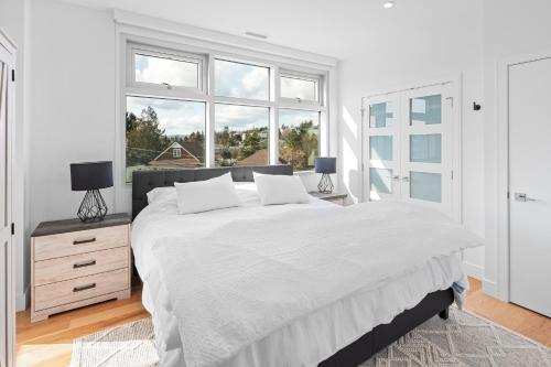 una camera bianca con un grande letto e una finestra di West Bay Topaz by Iris Properties! a Victoria