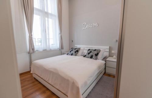 1 dormitorio con cama blanca y espejo en Main Square Dream Apartment, en Zagreb