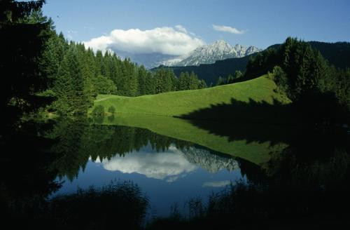 a reflection of a mountain in a body of water at Ferienhotel Tyrol Söll am Wilden Kaiser in Söll