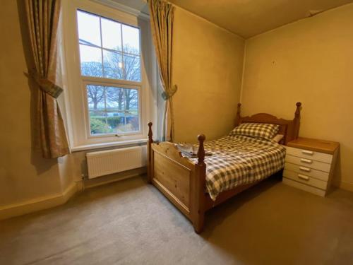 a bedroom with a bed and a window at Remarkable 3-Bed House in Millom in Millom
