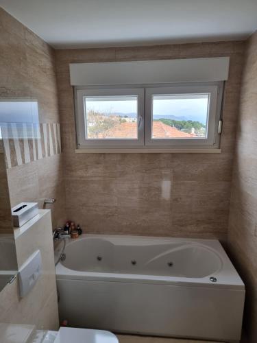 a bathroom with a bath tub and a window at Charming apartment, 2 garage parking in Split