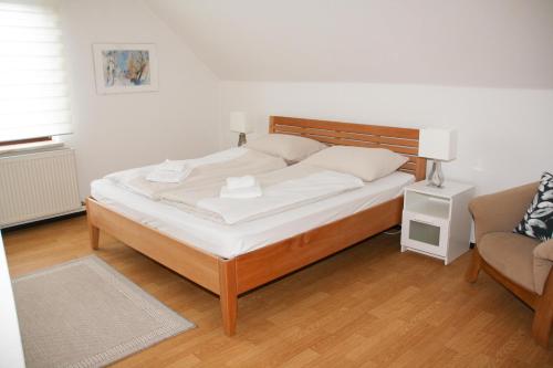 a bedroom with a bed and a couch and a chair at Haus Sonnental Velden am Wörthersee in Velden am Wörthersee