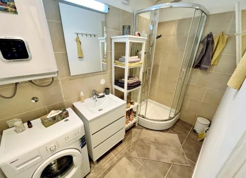 La salle de bains est pourvue d'un lave-linge et d'une douche. dans l'établissement Apartment Passage Inn, à Zagreb