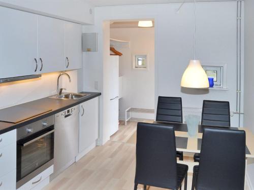 a kitchen and dining room with a table and chairs at Apartment Drita - 2-3km from the sea in Western Jutland by Interhome in Sønderby