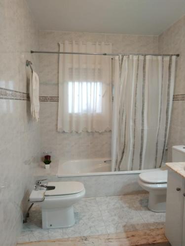 a bathroom with a toilet and a tub and a sink at El raconet del Riu in Deltebre