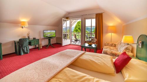 Hotel Drachenwand-Mondsee في موندزي: غرفة نوم بسرير كبير وغرفة معيشة