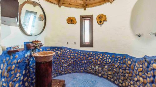 Pokój ze ścianą pokrytą kamieniami i lustrem w obiekcie Casa de Piedra La Laguna de Tiscar Puente Genil by Ruralidays w mieście Puente-Genil