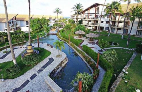 uma vista aérea de um resort com um rio e edifícios em Taiba Beach Resort - Apt Duplex Novo em Taíba