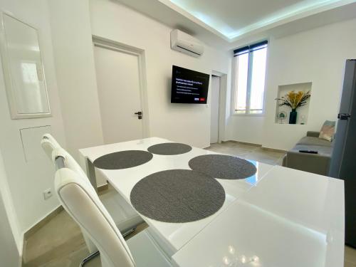 une table blanche et des chaises dans un salon dans l'établissement L'Esperance By SCLS Locations, à Cannes