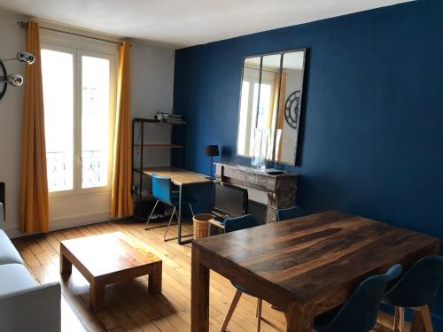 d'un salon avec une table en bois et des murs bleus. dans l'établissement Quiet apartment hill of Montmartre, à Paris