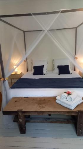 a bed in a canvas tent with a wooden bench at LA LANDE in Pleyber-Christ