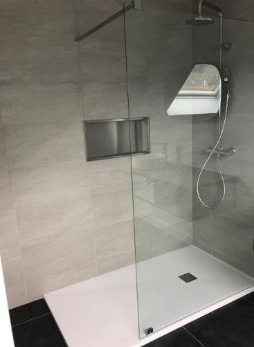 une douche avec une porte vitrée dans une salle de bain dans l'établissement Villa Marie-Lou entièrement rénovée, à Neuville-sous-Montreuil
