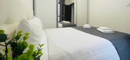 a bedroom with a bed with towels on it at River Place Apartment - Iulius Mall in Iaşi