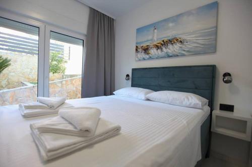 a bedroom with a white bed with two towels on it at Luxury Villa Lana Apt, Seaview Terrace, Large Outdoor Space, BBQ in Trogir