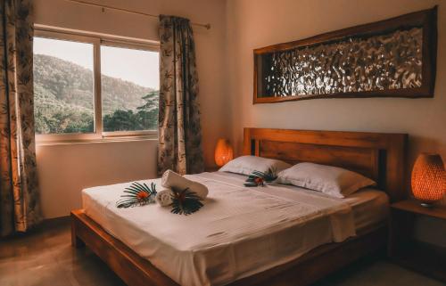 um quarto com uma cama grande e uma janela em kannel Apartments em Anse Royale