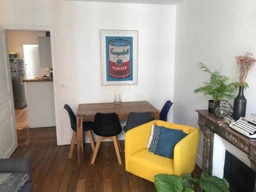 - un salon avec une table à manger et une chaise jaune dans l'établissement Charming apartment in Montmartre, à Paris