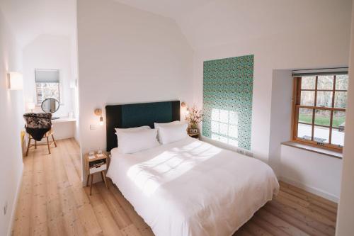een slaapkamer met een groot wit bed en een raam bij Slackbrae in Forest Mill