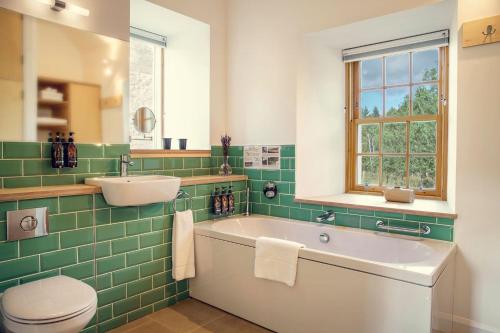 een badkamer met een bad, een wastafel en een toilet bij Slackbrae in Forest Mill