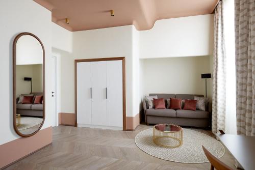 Palazzo Velabro, a Member of Design Hotels في روما: غرفة معيشة مع أريكة ومرآة