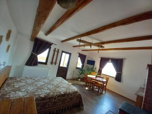 - une chambre avec un lit, une table et des chaises dans l'établissement Căsuța din Deal, à Tîrgu Neamţ
