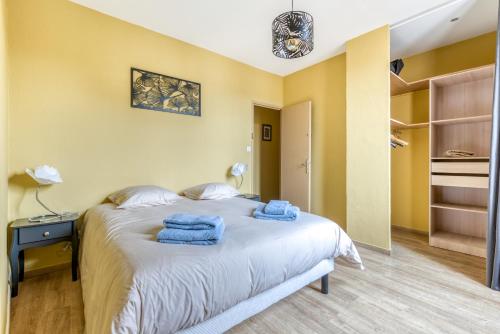 Un dormitorio con una cama con toallas azules. en Maison du capitole en Narbona