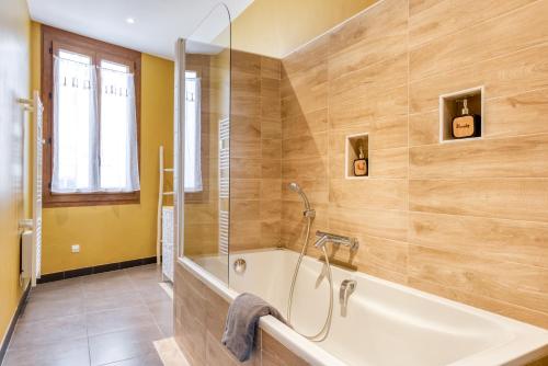 y baño grande con bañera y ducha. en Maison du capitole en Narbona